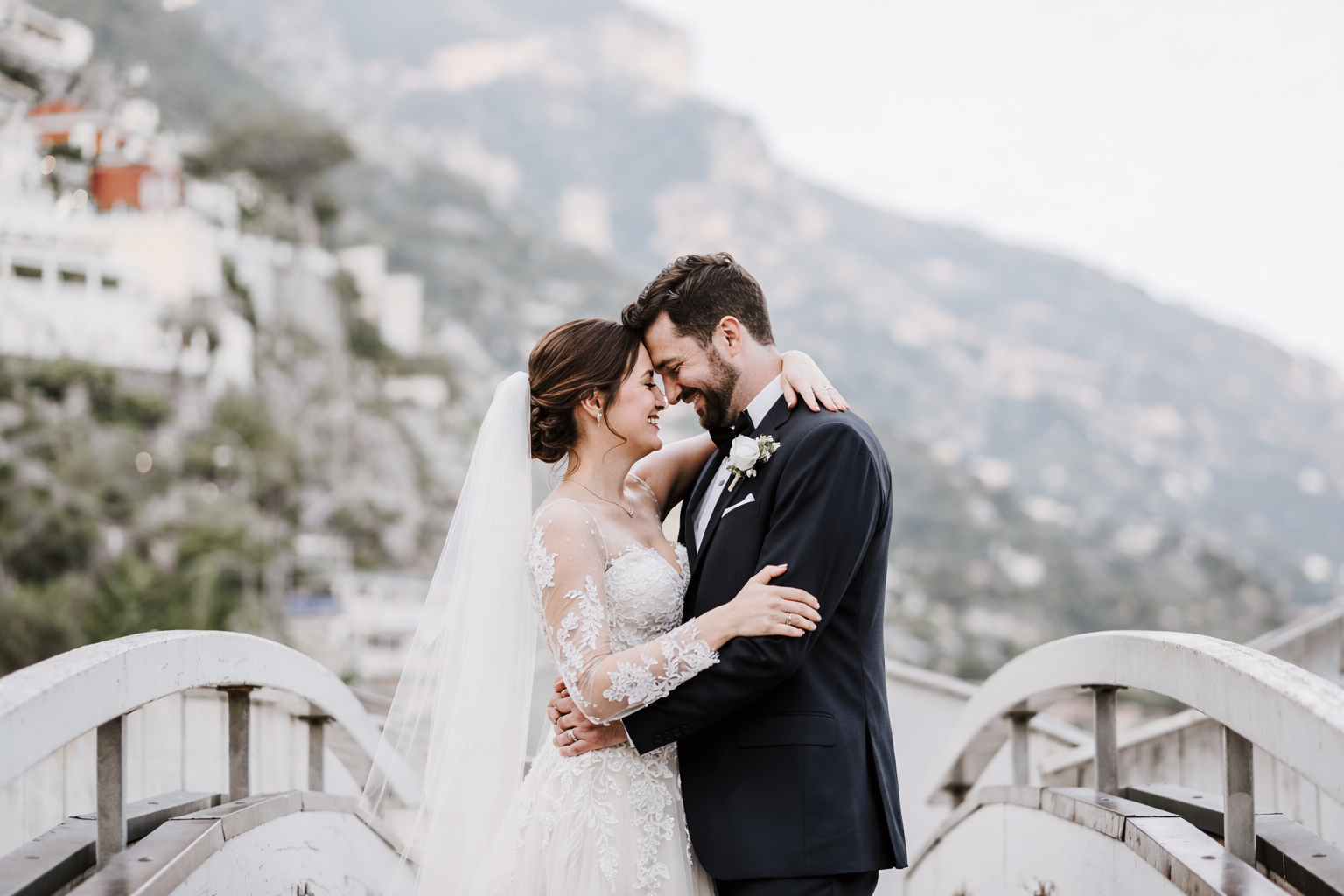 romantic newlywed couple embracing with Amalfi Coast cliffs and sea view in background